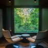 edelførst tree houses, © Robert Tober Interior view of a modern tree house with two armchairs and large window with forest view.