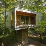 House on the foundation, © edelforst Baumhäuser © Robert Tober Modern tree house in the forest with balcony and glass front.