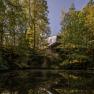 Baumhaus Lodge Schrems, © Niederösterreich Werbung / Maximilian Pawlikowsky Modernes Baumhaus in einem Wald, das sich in einem ruhigen Teich spiegelt.