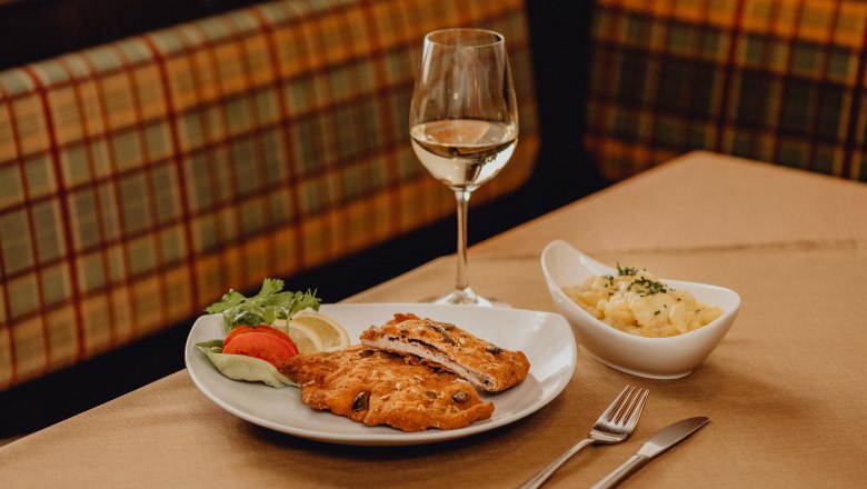 Waldviertel Sepp Cordon bleu, © Niederösterreich Werbung/Klaus Engelmayer Ein Teller mit Cordon bleu, Salatgarnitur und ein Glas Weißwein auf einem Tisch.