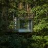Ein modernes Baumhaus inmitten eines dichten Waldes.