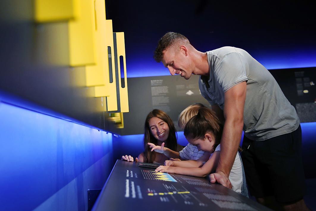 Eine Familie interagiert mit einer Ausstellung in einem Museum.
