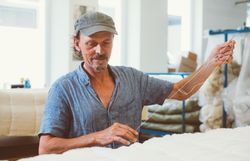 Ein Mann bereitet Stoffe für die Fertigung in der Waldviertler Schuhwerkstatt vor