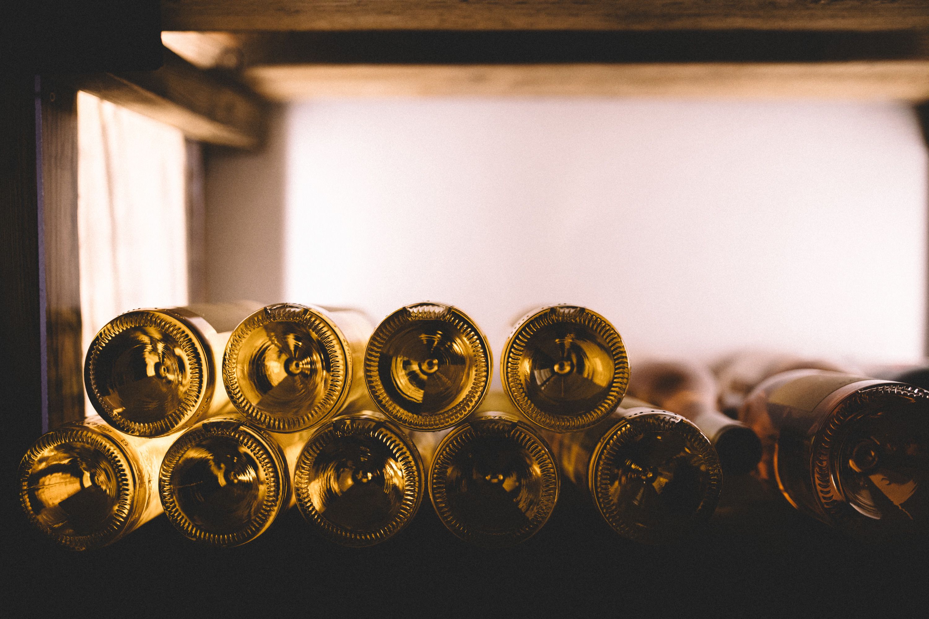 Nahaufnahme von Weinflaschen in einem Regal, die horizontal gestapelt sind.