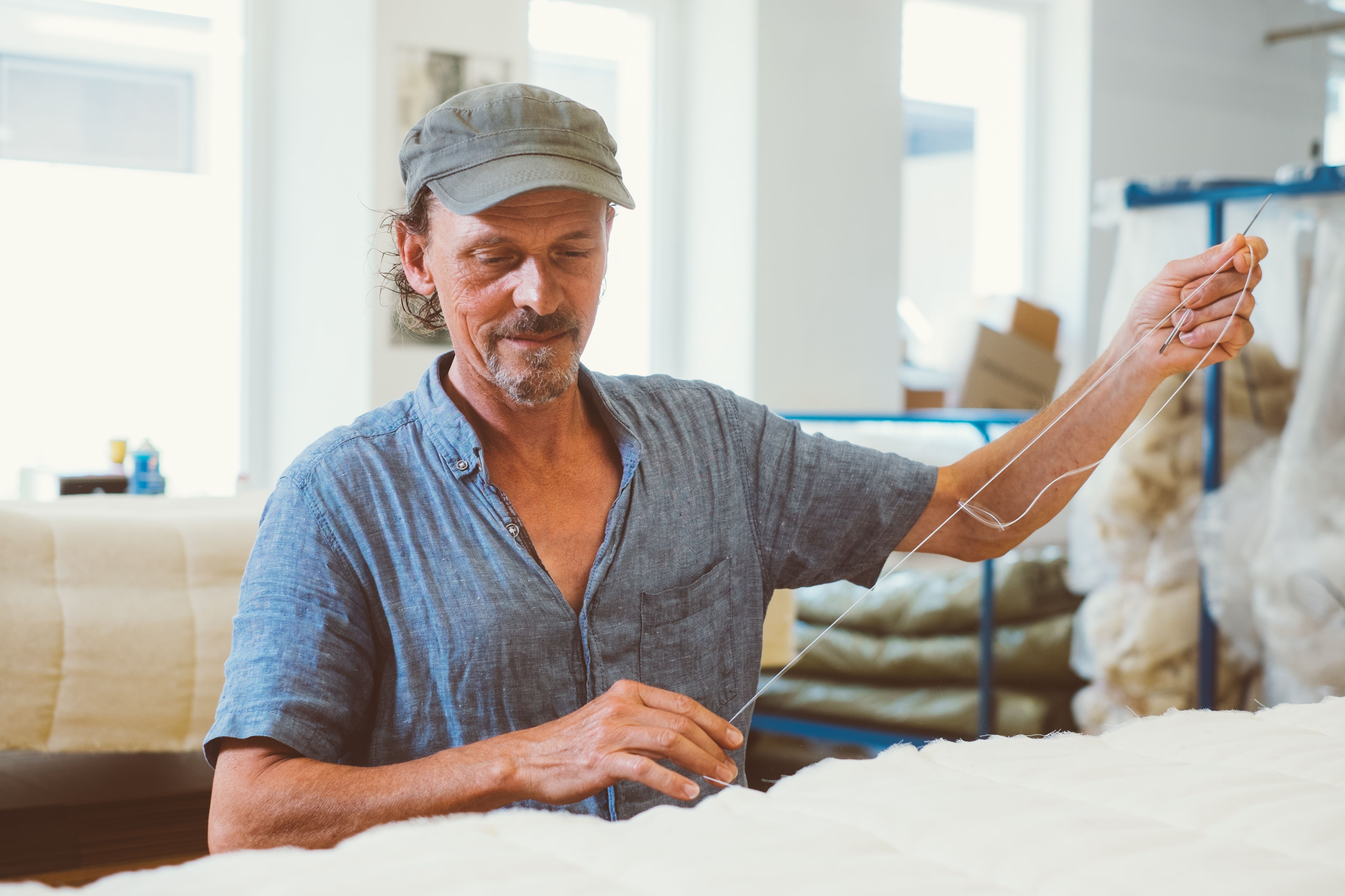 Ein Mann bereitet Stoffe für die Fertigung in der Waldviertler Schuhwerkstatt vor